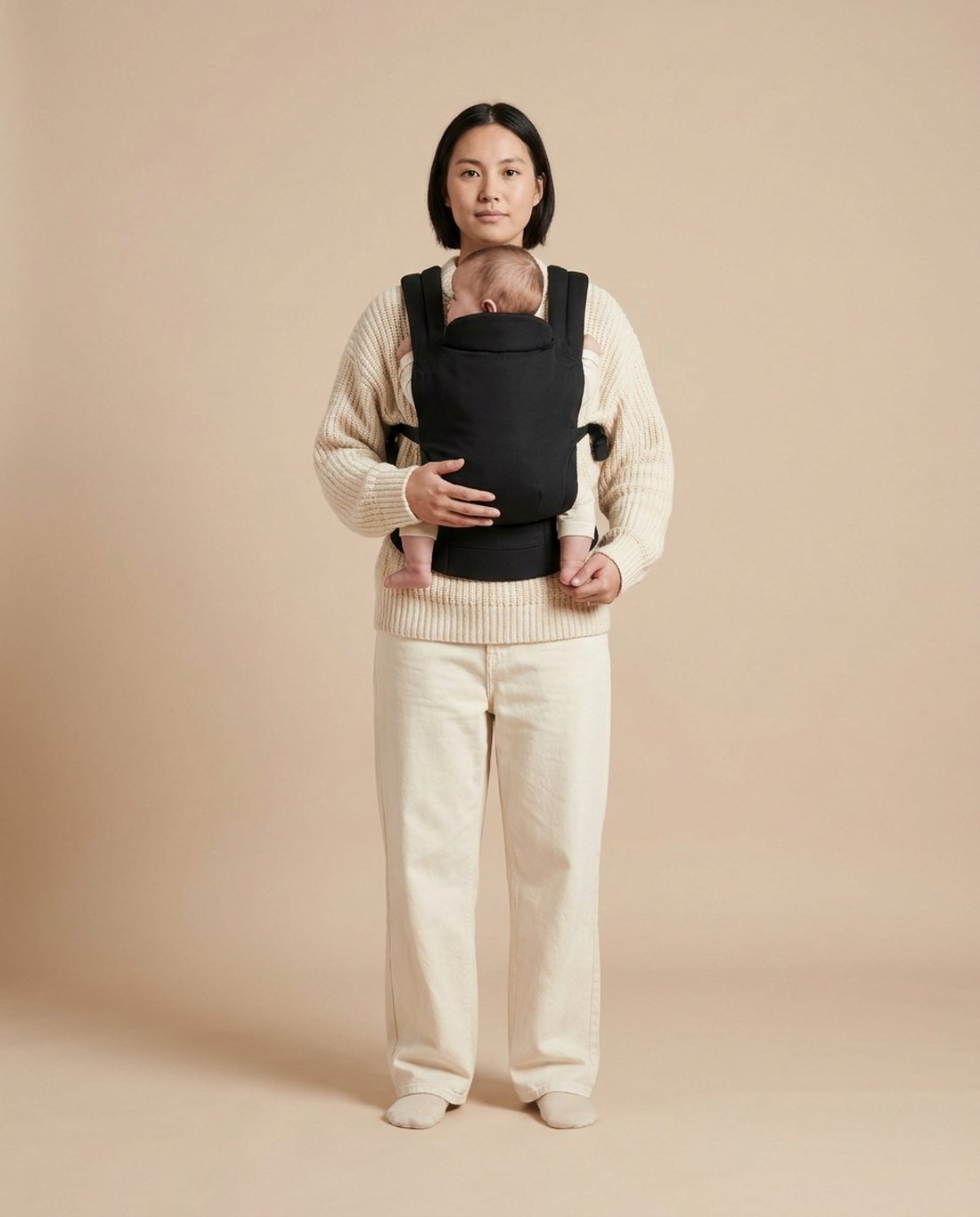 Parent wearing a baby carrier, studio portrait