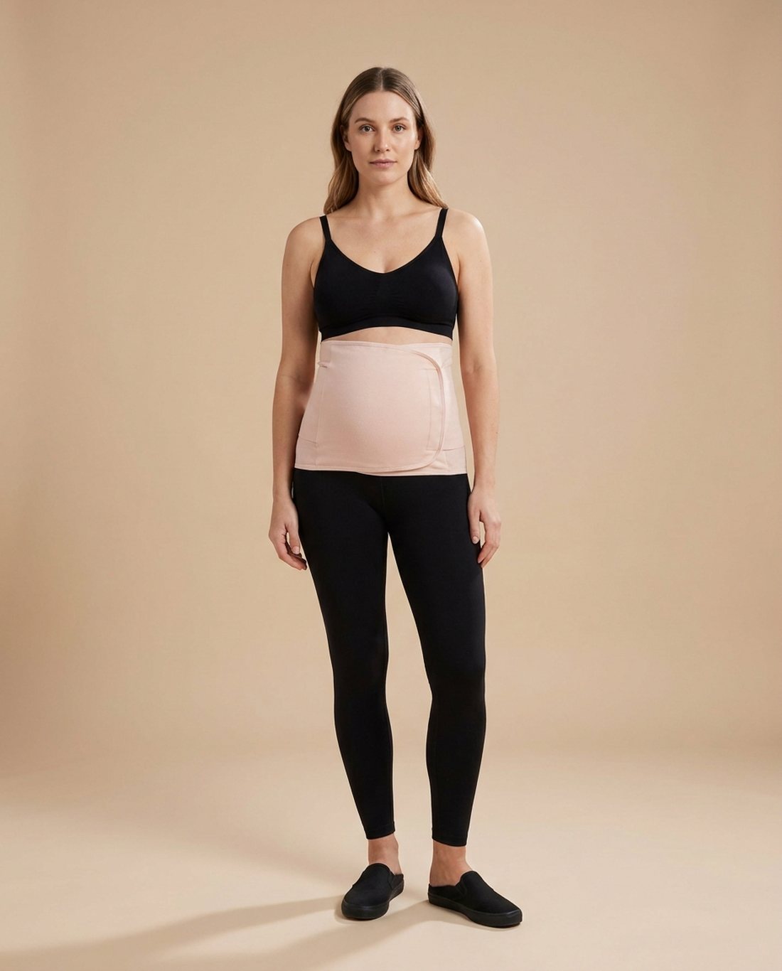 Postpartum belly wrap worn over leggings, studio portrait